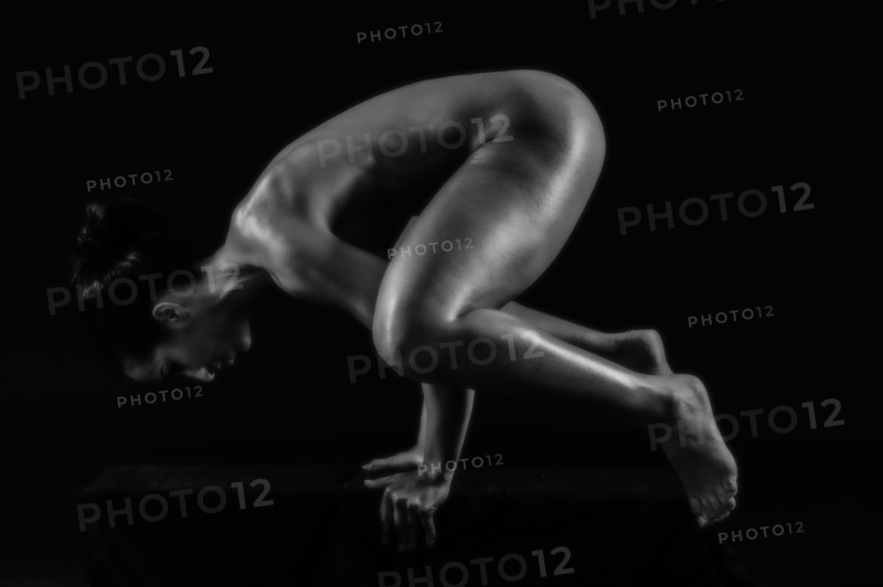 Naked muscular Mixed Race woman balancing on hands
