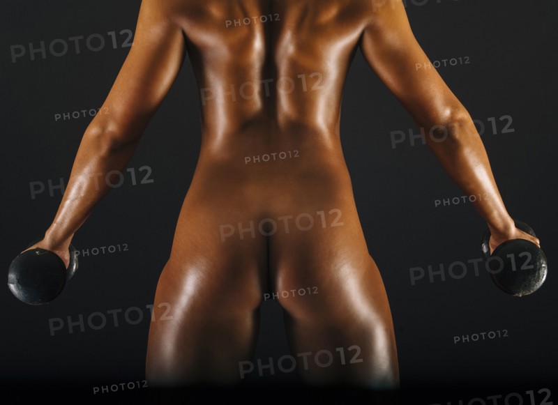 Naked muscular Mixed Race woman holding barbells