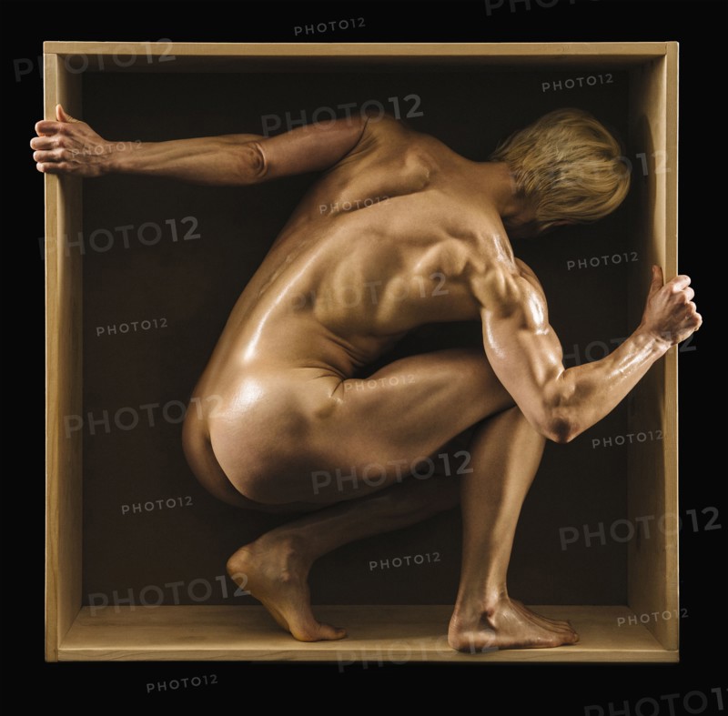 Muscular Caucasian woman crouching in box