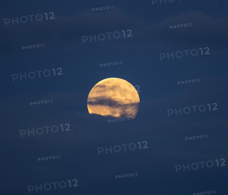 Clouds in sky in front of full moon