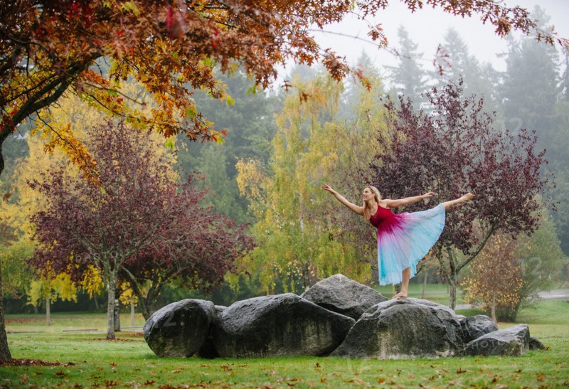 Caucasian ballerina dancing on rocks in park