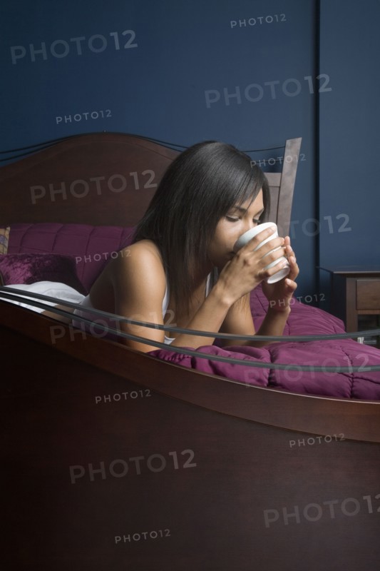Mixed Race woman drinking coffee