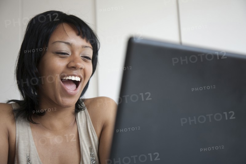 Grinning woman looking at laptop