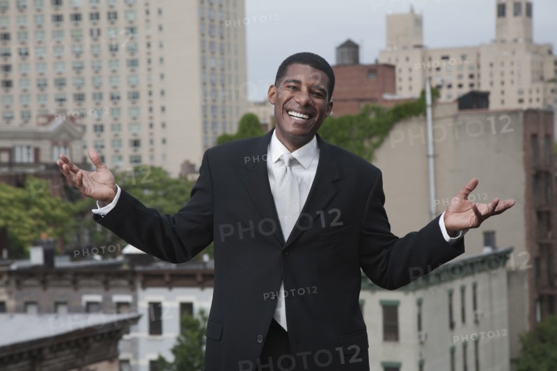 African American man in suit standing on rooftop