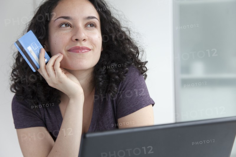 Hispanic woman shopping online with credit card
