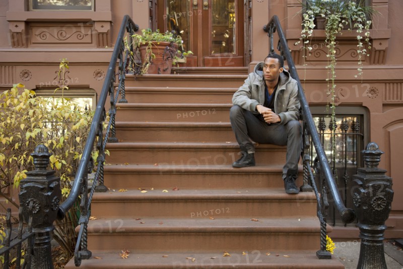 Black man sitting on front stoop