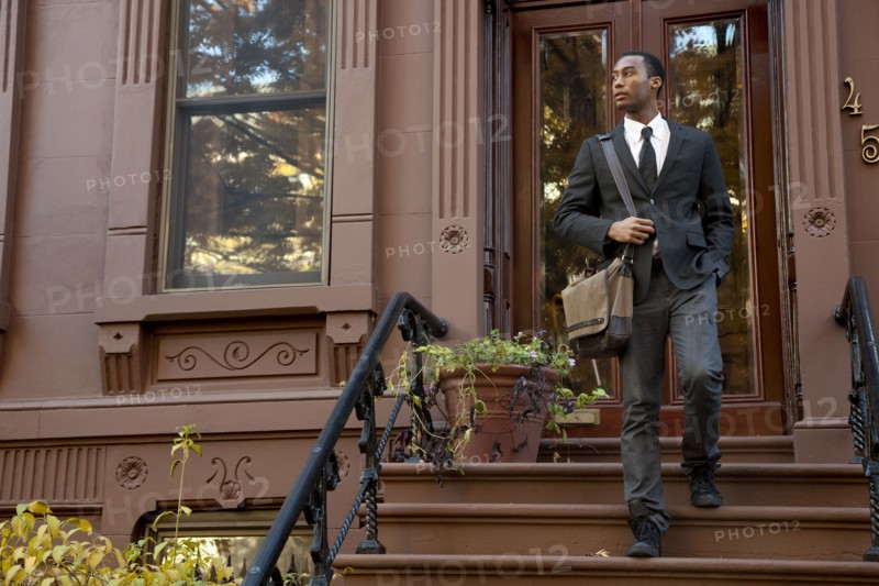 Black businessman walking down front stoop steps