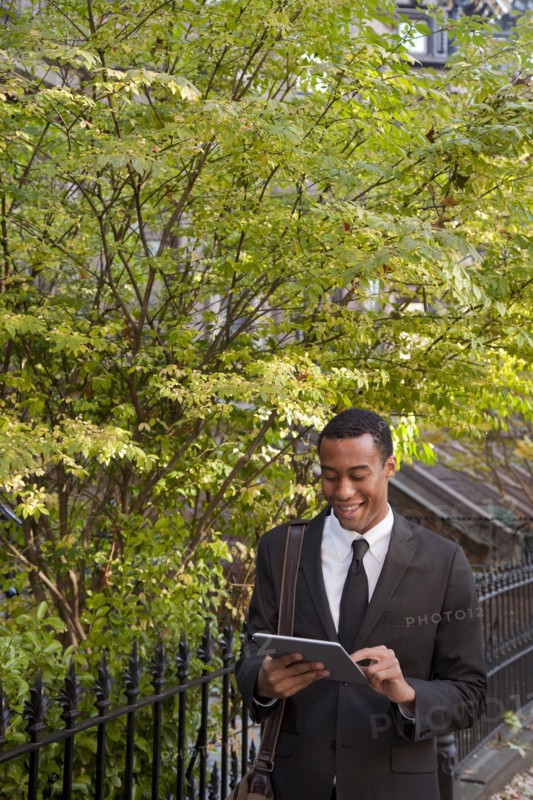 Black businessman using digital tablet outdoors
