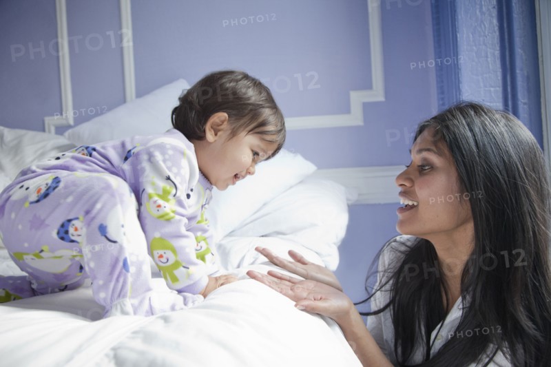 Sri Lankan mother taking baby girl off bed