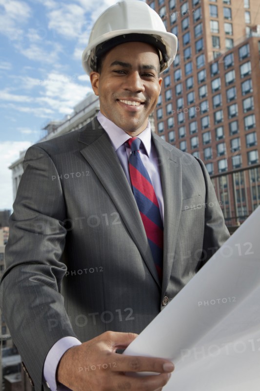 Black architect looking at blueprints