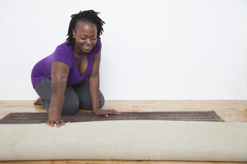 Black woman unrolling carpet