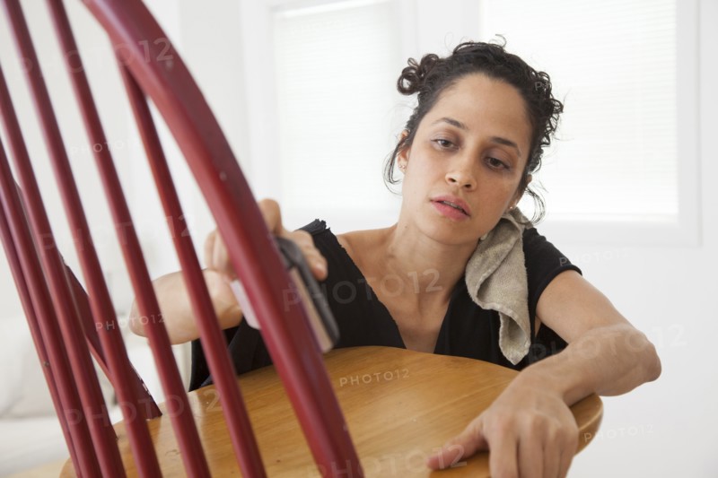 Hispanic woman sanding chair