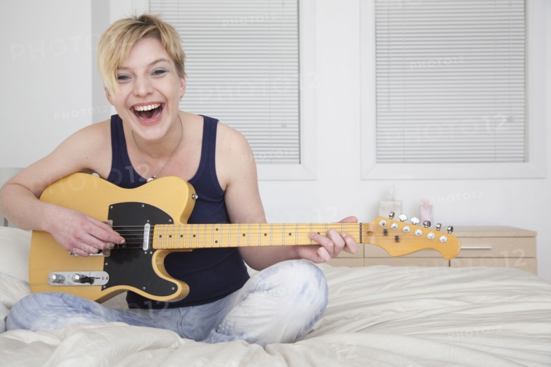 Caucasian woman playing electric guitar