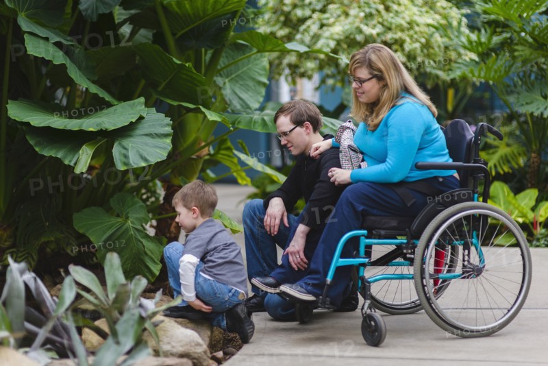 Paraplegic woman and family admiring plants