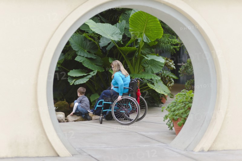 Paraplegic mother and son admiring plants