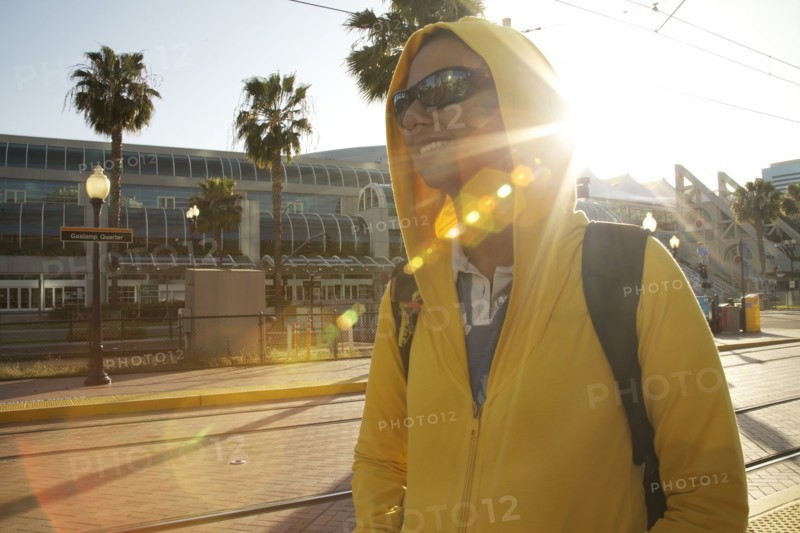 Mixed race woman in hoody and sunglasses walking