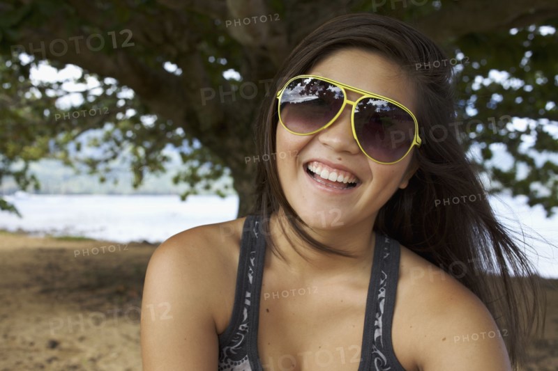 Smiling mixed race teenager in sunglasses
