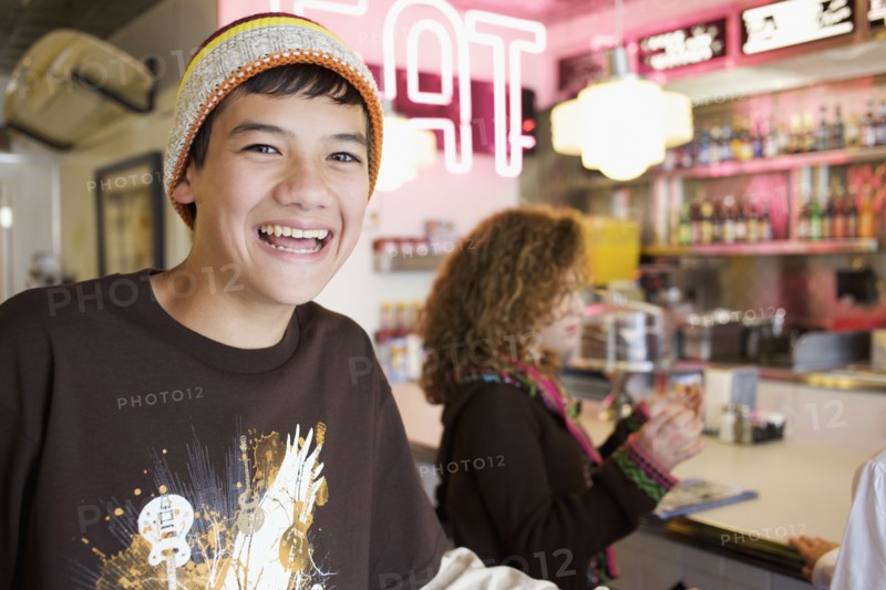 Mixed race boy smiling in cafe