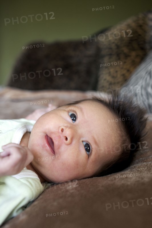 Mixed race newborn baby laying on blanket