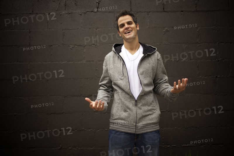 Smiling Caucasian man shrugging