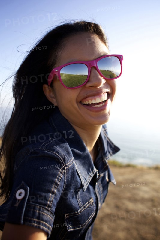 Smiling mixed race woman laughing on beach