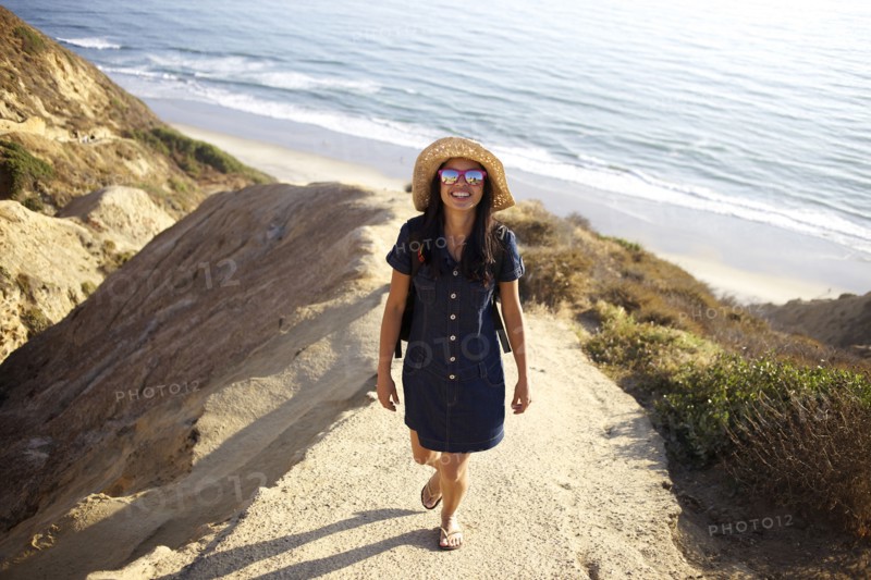 Mixed race woman standing on rock at beach