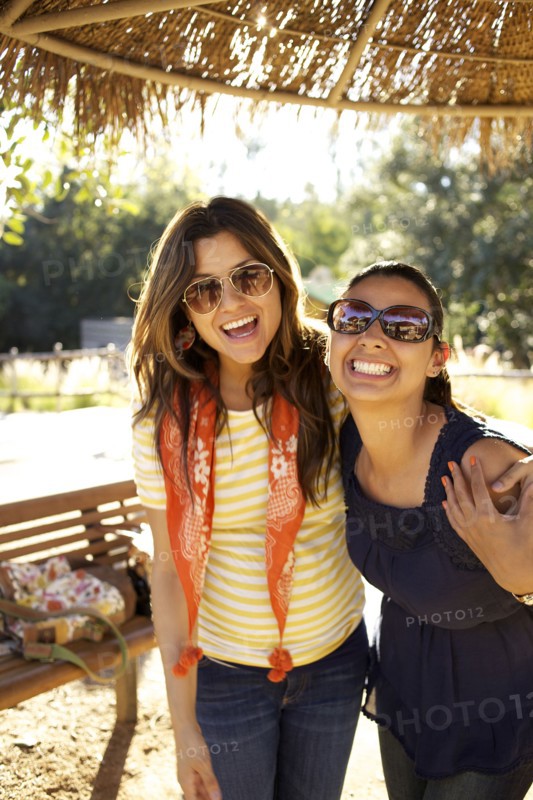 Smiling mixed race sisters hugging