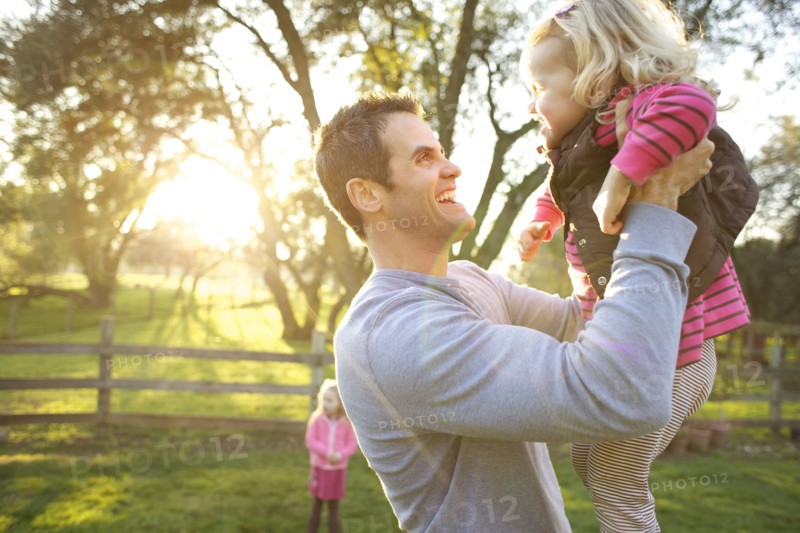 Caucasian father lifting daughter