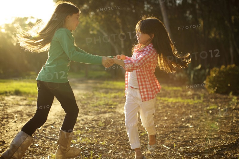 Mixed race sisters dancing in circle together