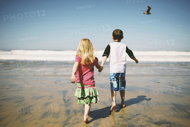 Children walking together on beach