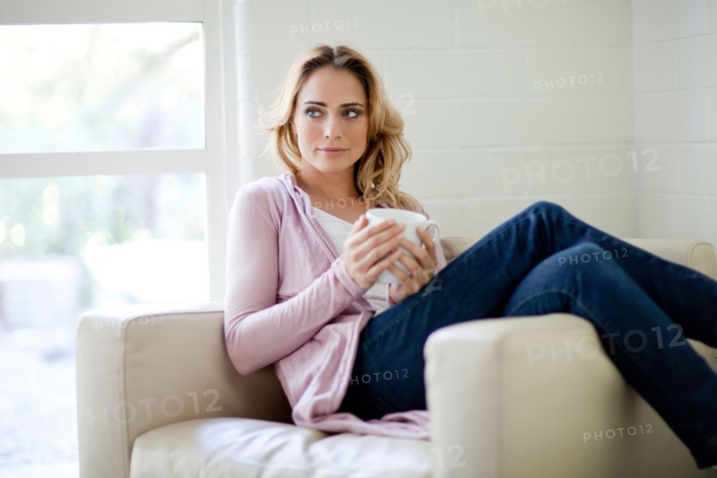 Caucasian woman sitting in chair drinking coffee