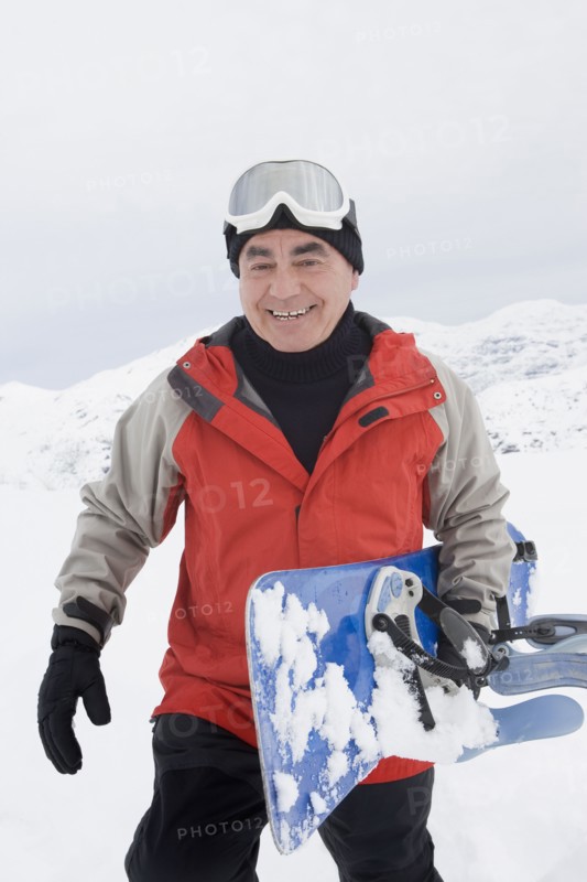 Senior Hispanic man snowboarding