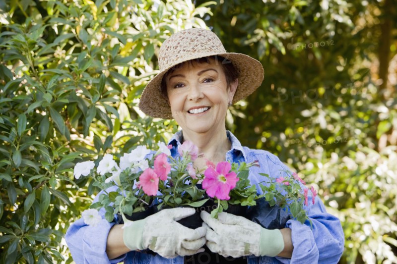 Hispanic woman in garden holding flowers