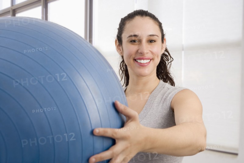 Mixed race woman holding large exercise ball