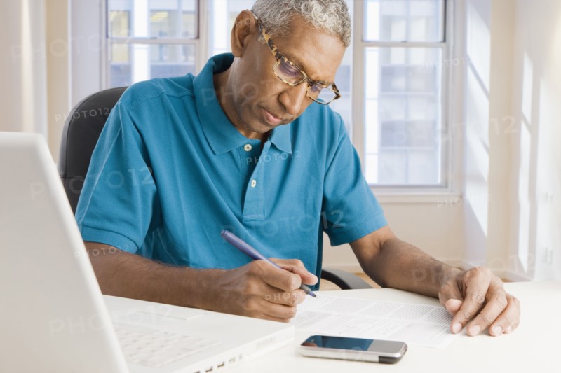 Mixed race man paying bills online