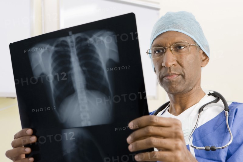 Mixed race surgeon looking at x-rays