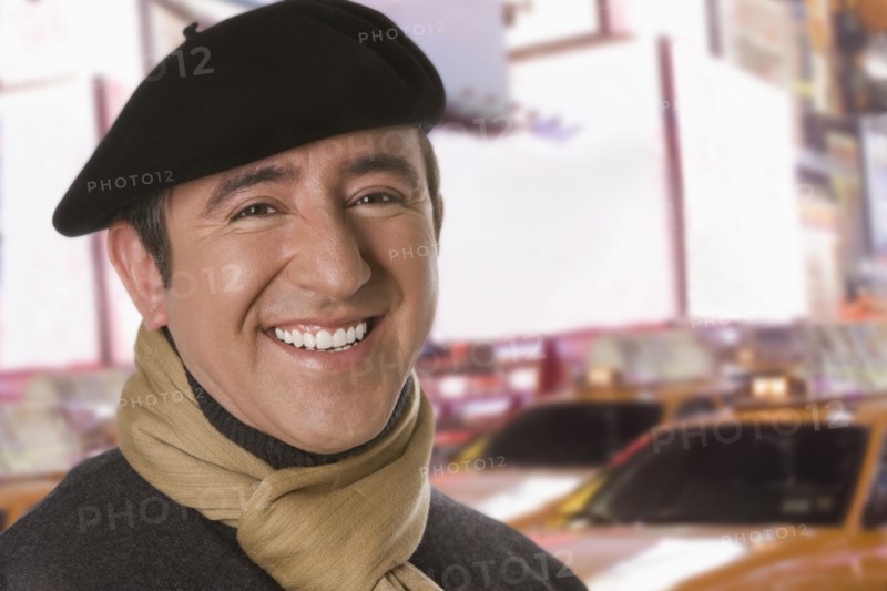 Hispanic man in beret on city street