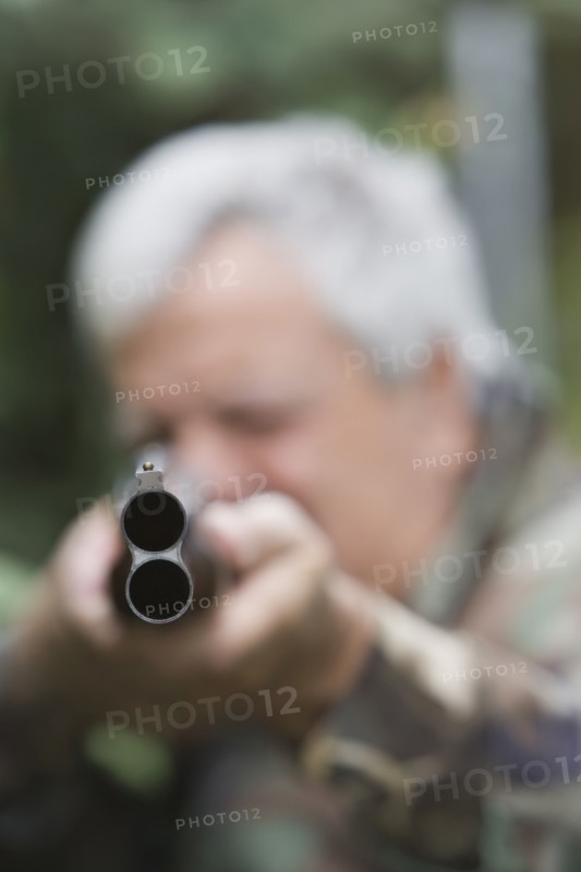 Senior Chilean man pointing shotgun