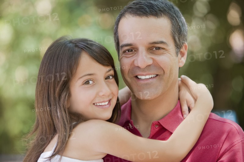 Hispanic daughter hugging father