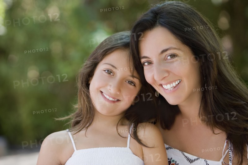 Smiling Hispanic mother and daughter