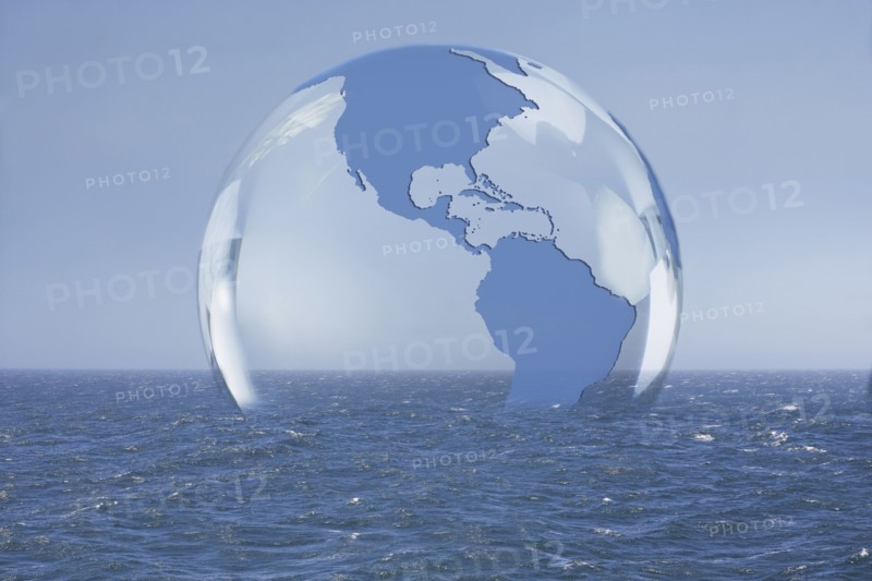 Transparent globe floating on ocean