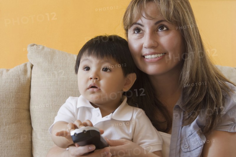 Hispanic mother and son watching television