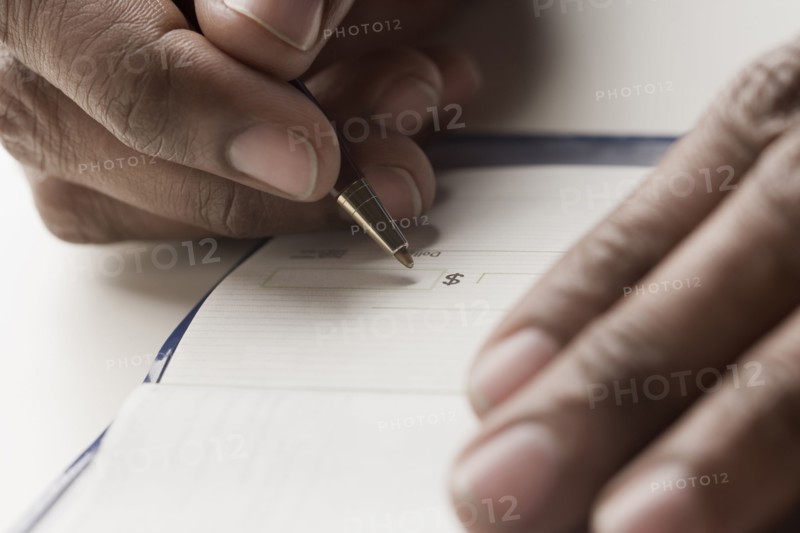 Mixed race man writing a check