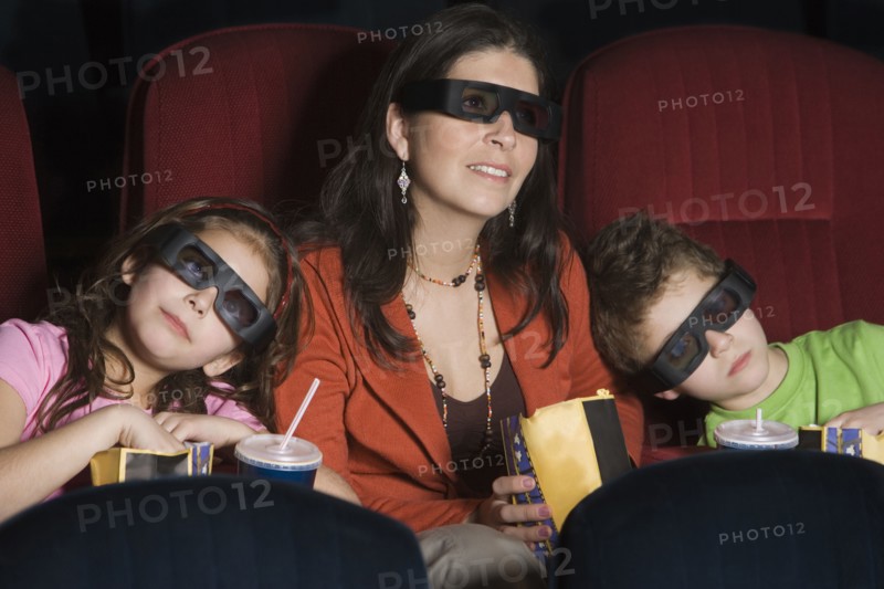 Hispanic mother and children watching 3D movie