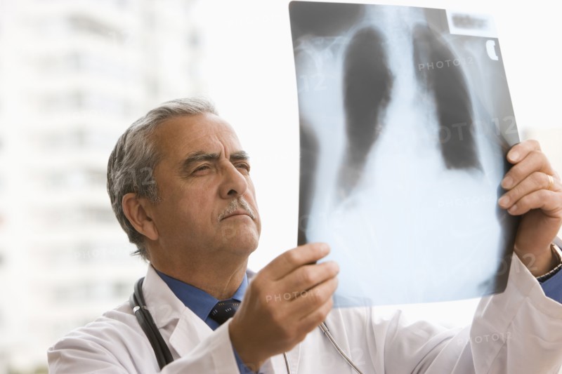 Hispanic doctor looking at x-ray