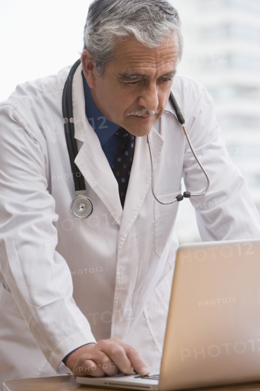 Hispanic doctor using laptop
