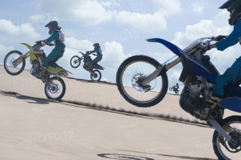 Chilean teenagers riding motorcycle on sand dune