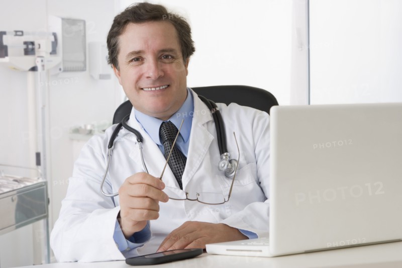 Caucasian doctor sitting at desk with laptop