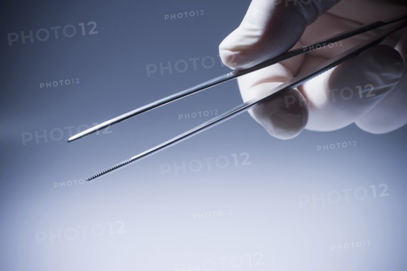 Close up of Hispanic doctor holding tweezers