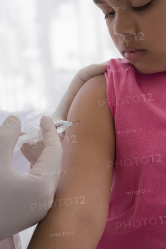 Hispanic doctor giving patient injection in arm